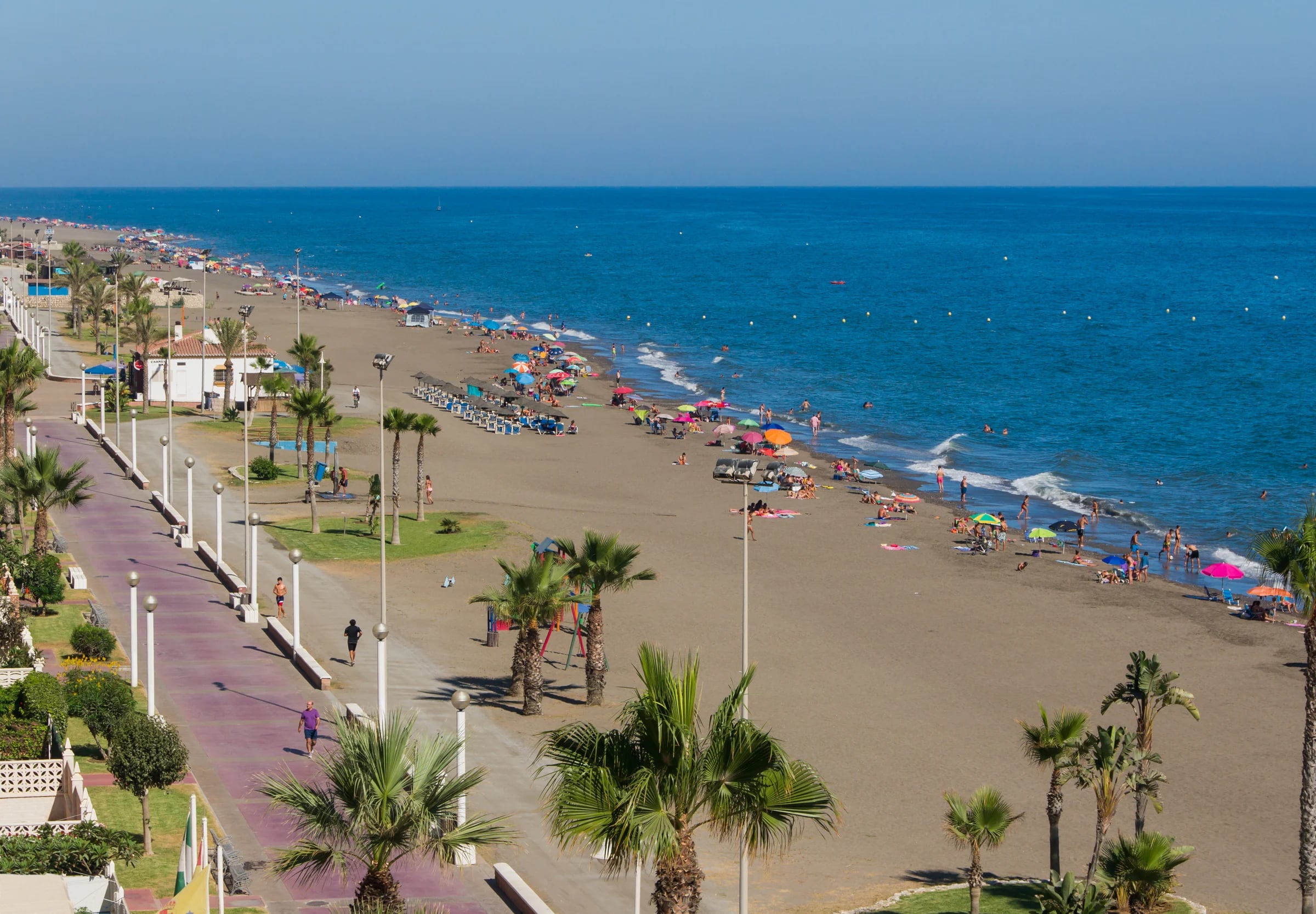 Paseo marítimo y playa de Rincón de la Victoria vistos desde lo alto, con palmeras junto a la arena