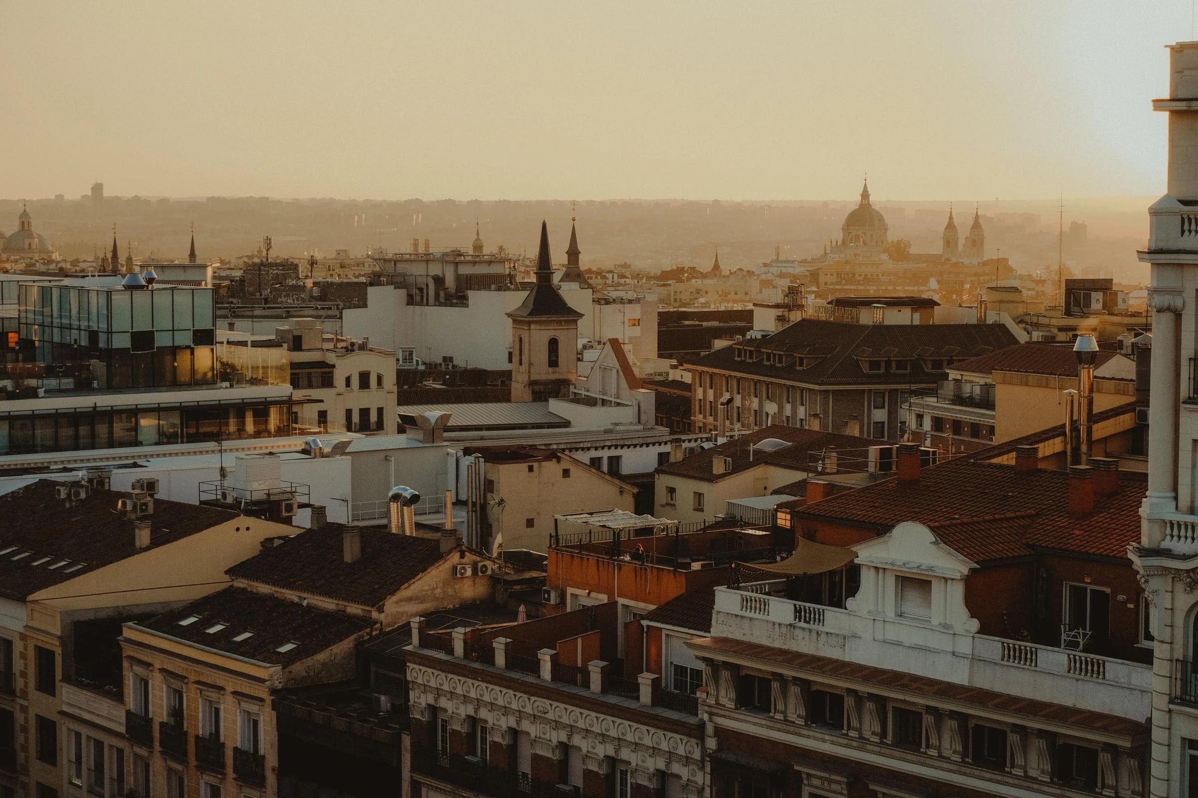 Tejados del centro de Madrid al atardecer, con cúpulas al fondo