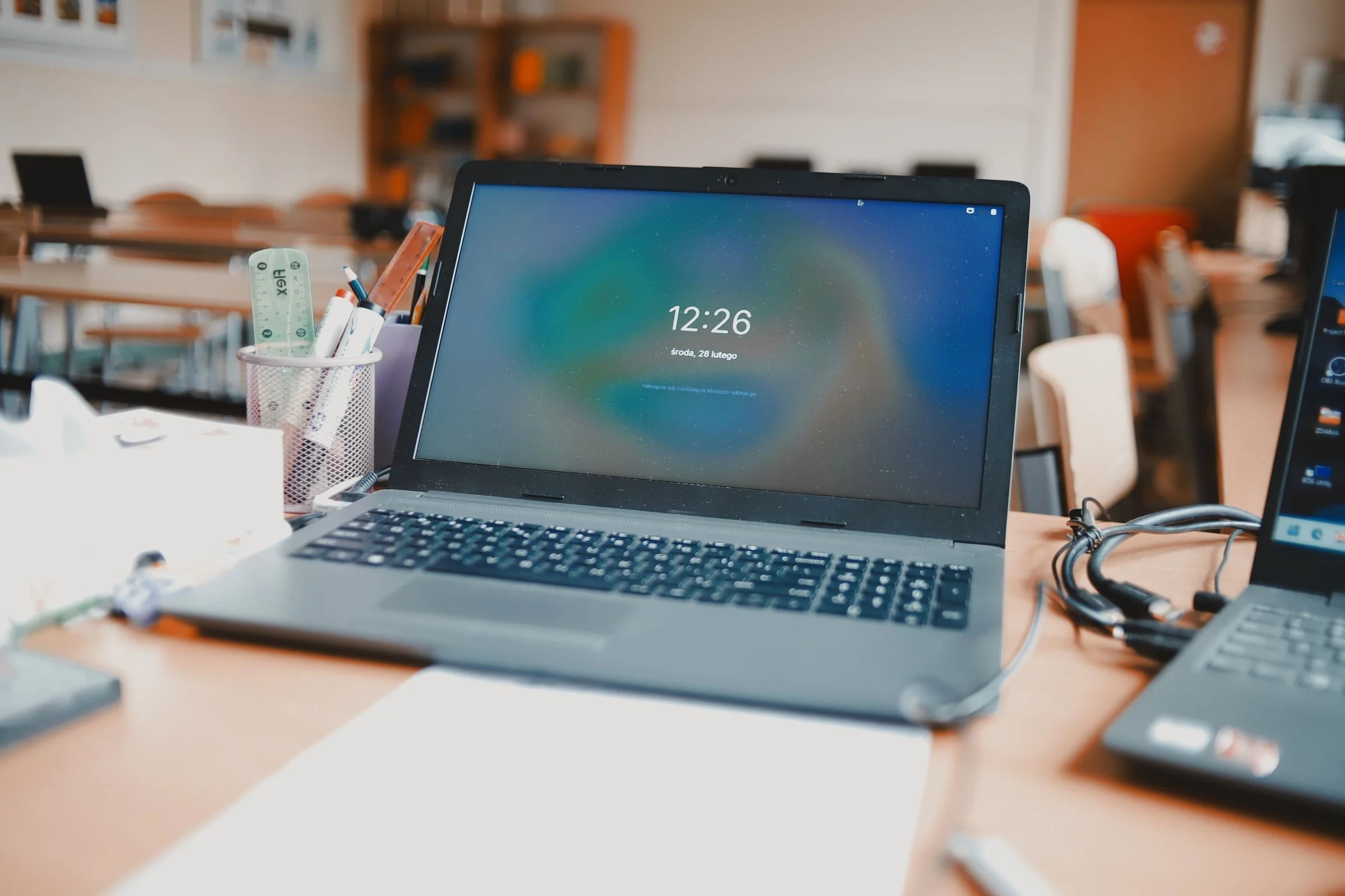 Portátil con la pantalla de bloqueo encendida sobre una mesa de trabajo