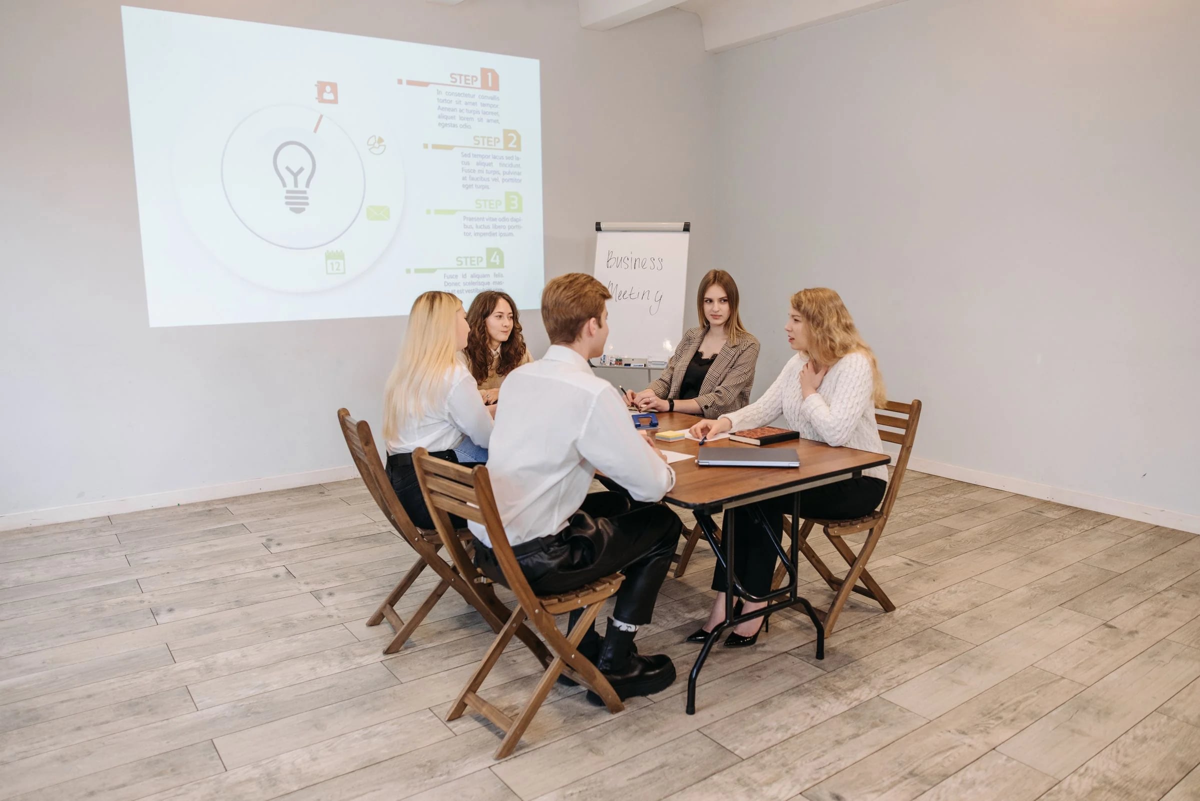 Grupo reducido en una sesión de formación alrededor de una mesa, con una presentación proyectada