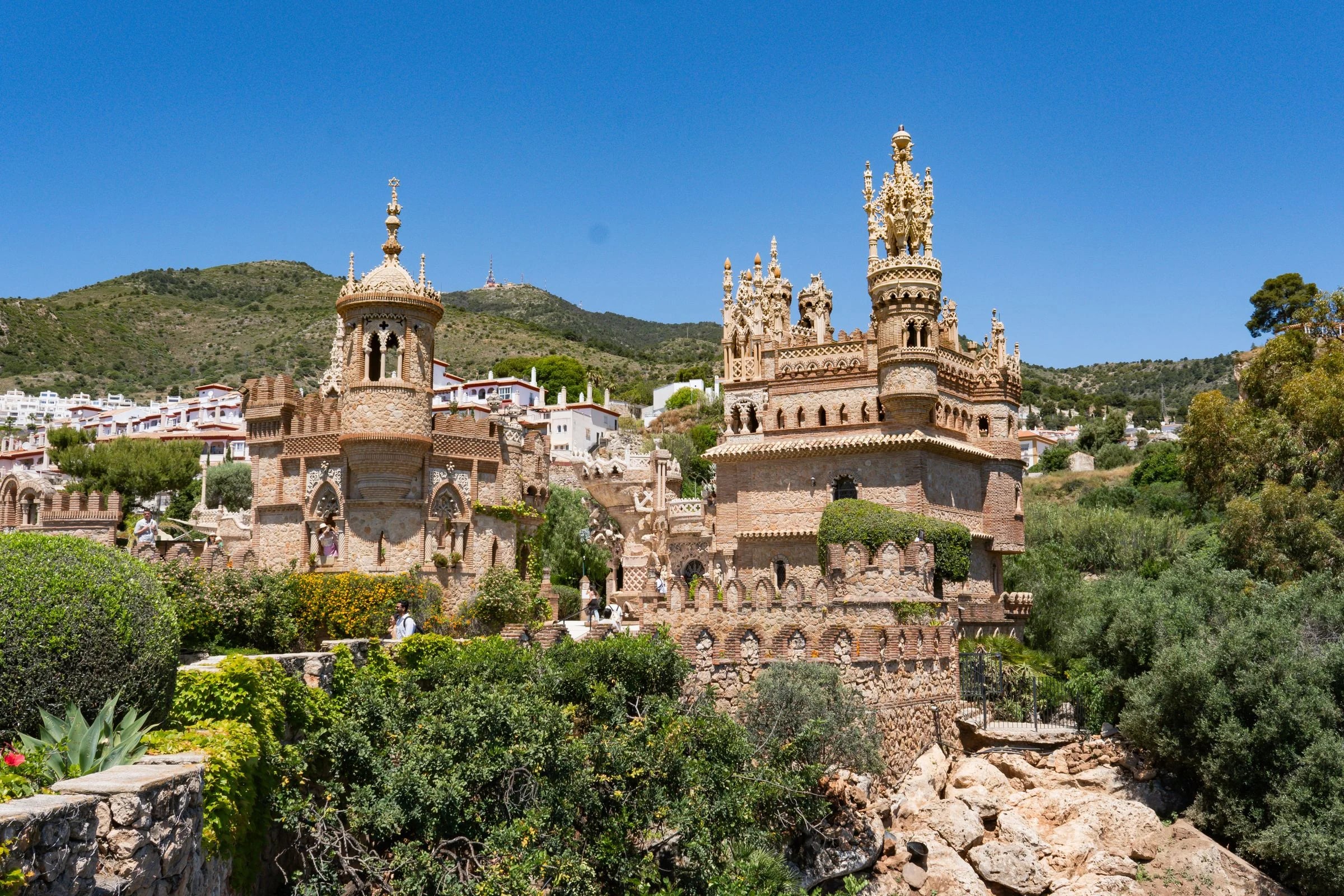 Castillo de Colomares en Benalmádena, rodeado de vegetación bajo un cielo azul